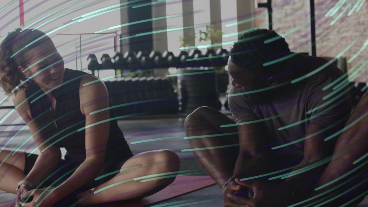 Right partner adjusting foot to prompt smiles, starting joint stretch, teal streaks overlaying gym
