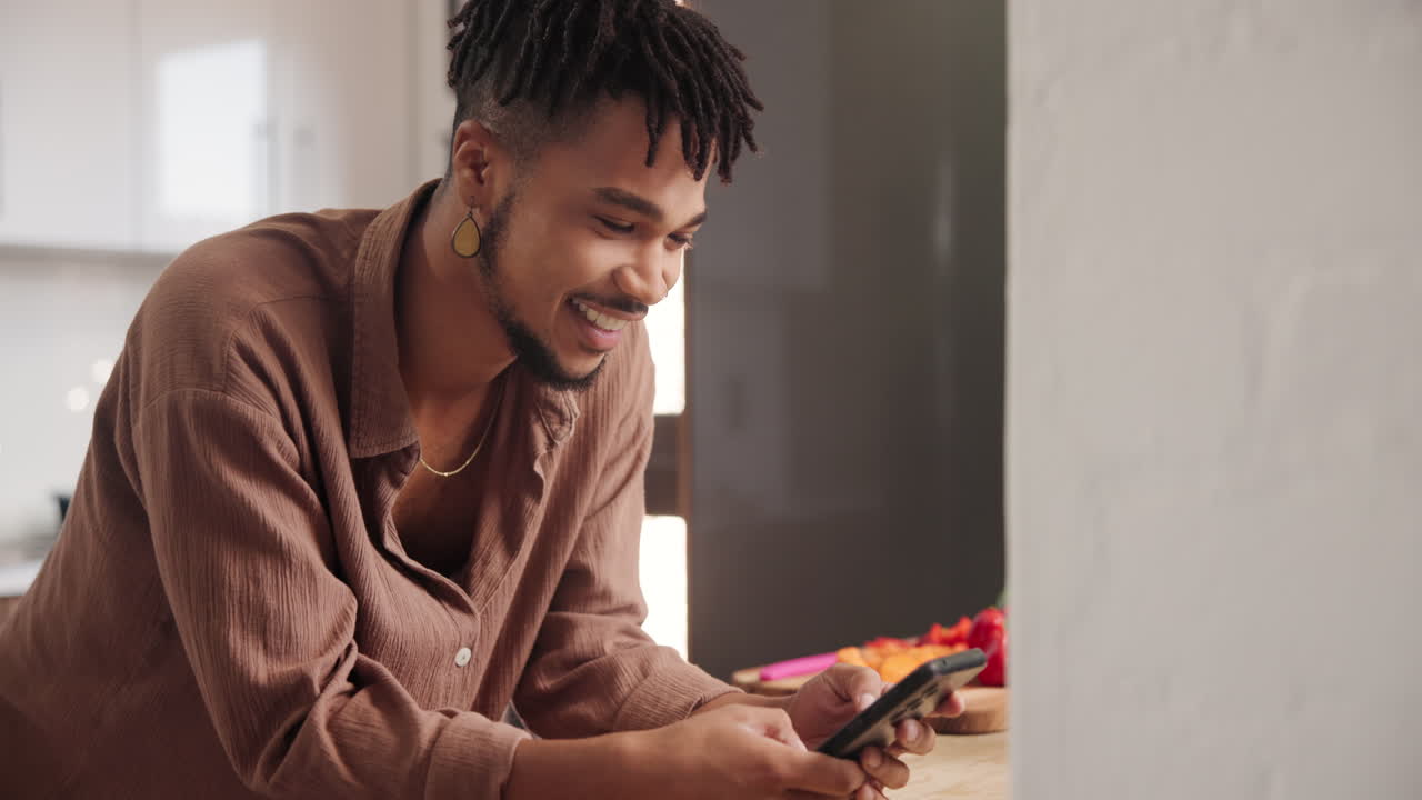 hombre usando el teléfono en la cocina