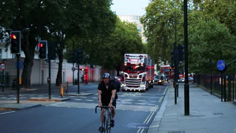 cyclist passes truck on a busy street