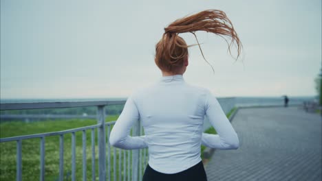 redhead woman jogging in park