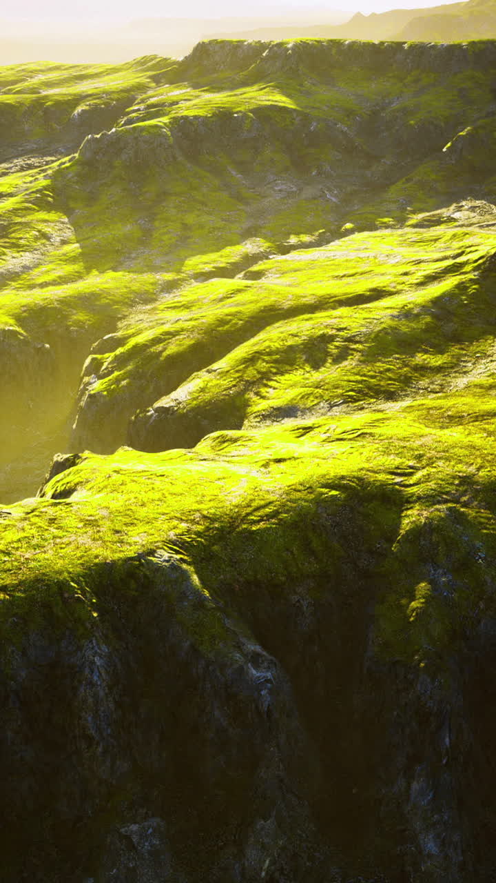 Lush green hills with soft sunlight illuminating the rugged terrain