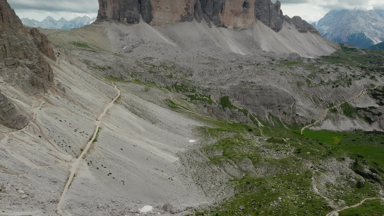 Slow drone reveal shot of Tre Cime di Lavaredo in Dolomites, Italy on a cloudy day