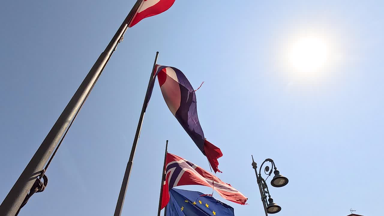 Flags of various countries waving under the sun