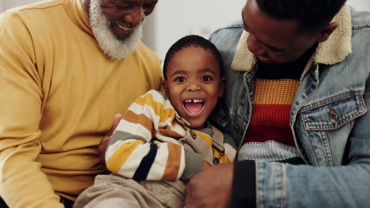 дедушка, отец и ребенок играют на диване