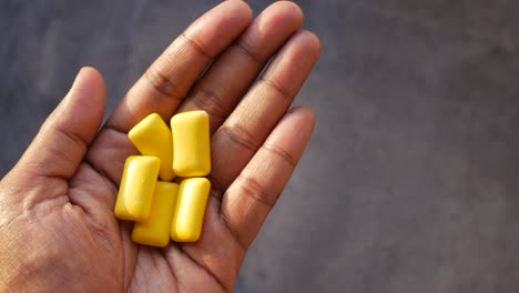 hand holding yellow chewing gum