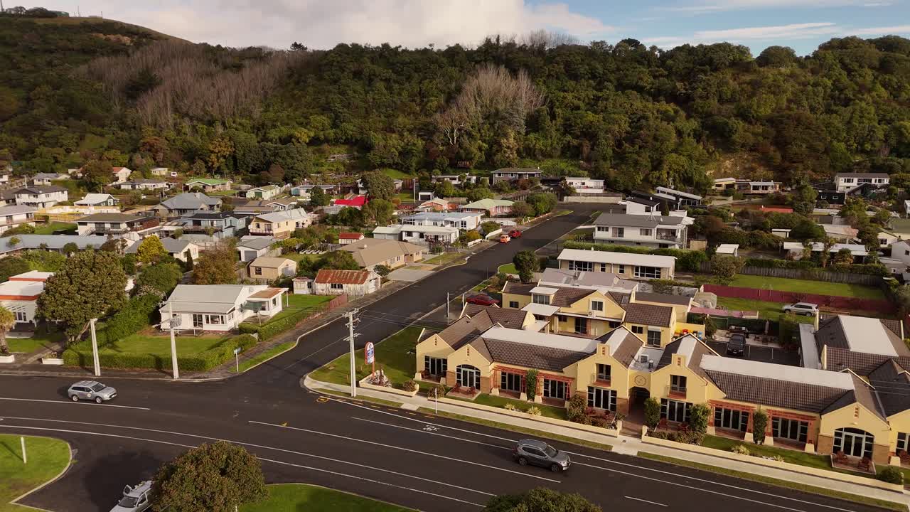 Luxury houses and homes along coastal road with cars at sunset. Aerial view. New Zealand South Island, Kaikoura Area