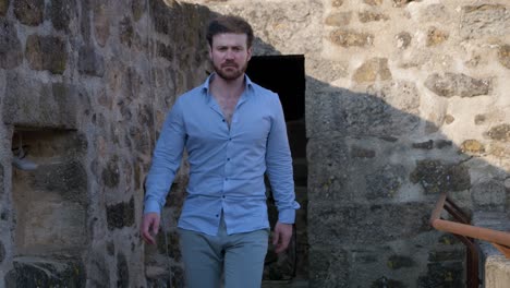 Male-walking-into-the-camera-in-slowmotion-at-a-castle-in-southern-France