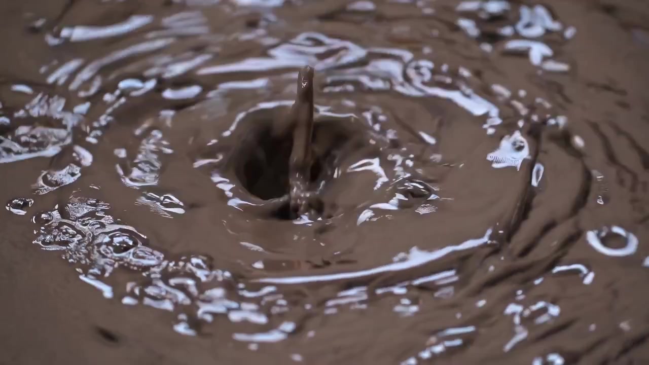 Primo piano di goccioline di cioccolato liquido che creano increspature