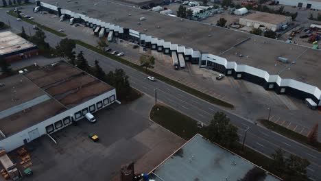 Reveladora-Toma-De-Drone-De-Las-Bahías-En-El-Almacén-Con-Semirremolques-Estacionados-En-Calgary,-Alberta.