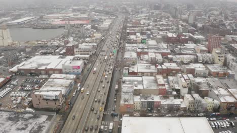 brooklyn queens expressway pan up en la tormenta de invierno aérea 4k horizonte de manhattan de nueva york