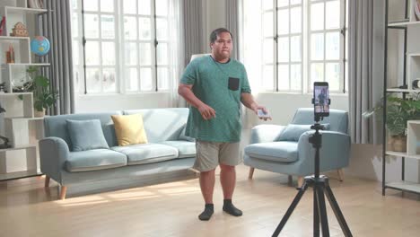 asian man blogger shoots video content for social networks by smartphone camera, magician with playing cards