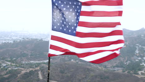 american flag overlooking los angeles on a gloomy day