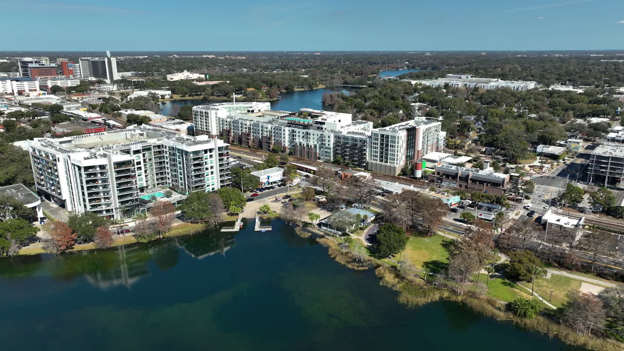 Uma vista panorâmica de drone sobre o Lago Ivanhoe destaca o desenvolvimento moderno e a vida urbana à beira-mar perto do centro de Orlando.