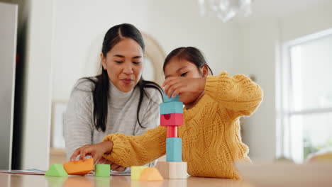 mother playing with building blocks with her girl