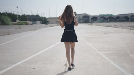 woman walking down an empty urban parking lot