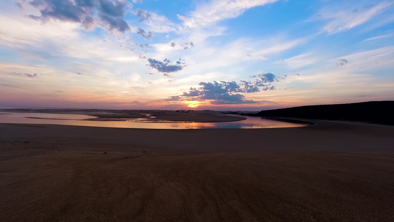 lapso de tiempo del reflejo de la puesta de sol sobre la desembocadura del río y las dunas de arena, áfrica