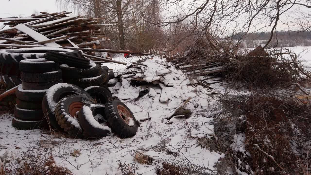 Pile of old rubber tires thrown away in nature, unclean countryside yard