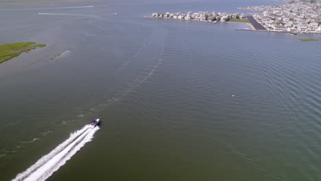 Amazing-long-tracking-shot-from-Drone-following-a-boat-speeding-up-with-two-jetskis-following-in-wake