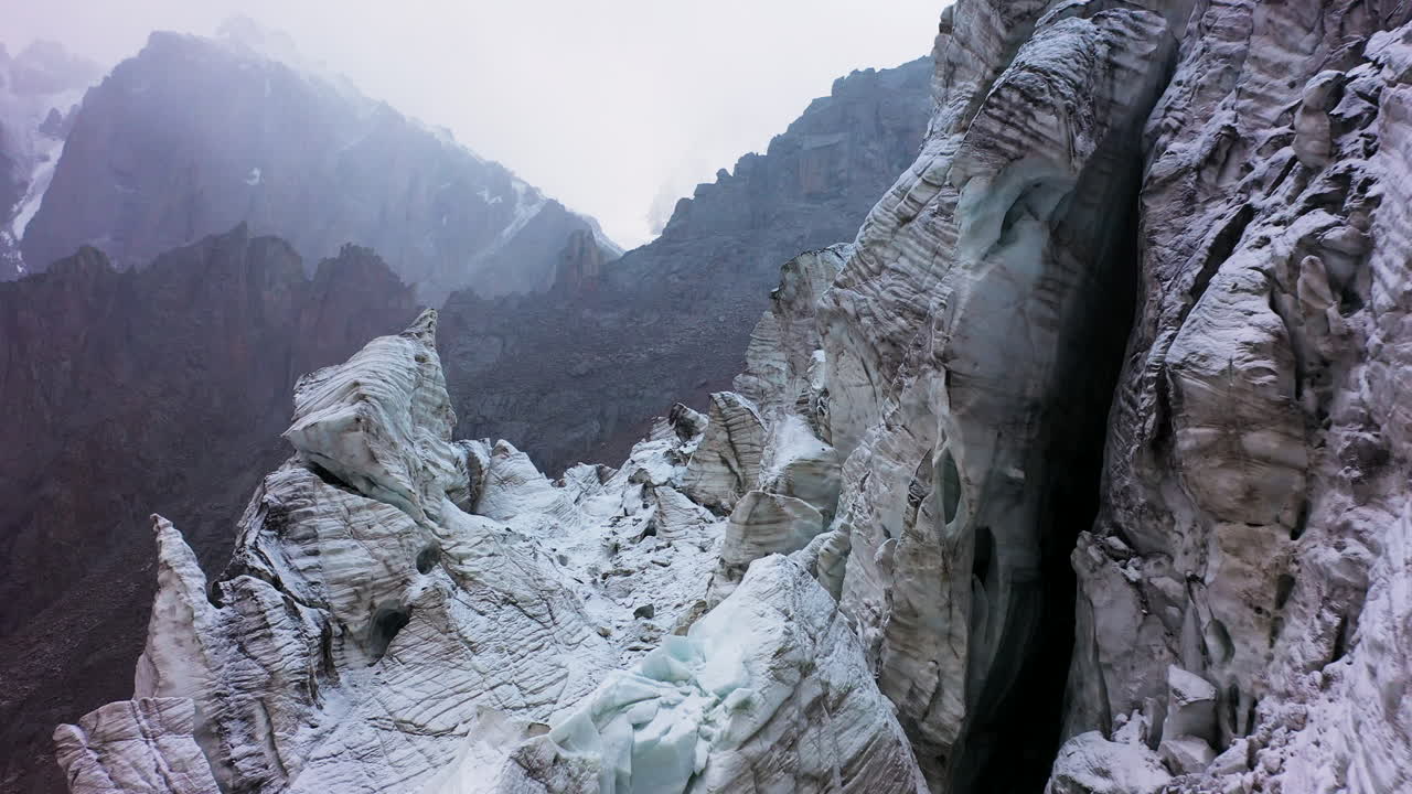 Cena épica de drone cinematográfica aérea atravessando uma grande passagem no glaciar Ak-Sai no Quirguistão