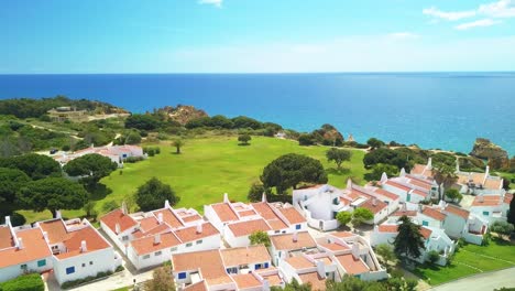 aerial shot of village next to the ocean in algarve, portugal