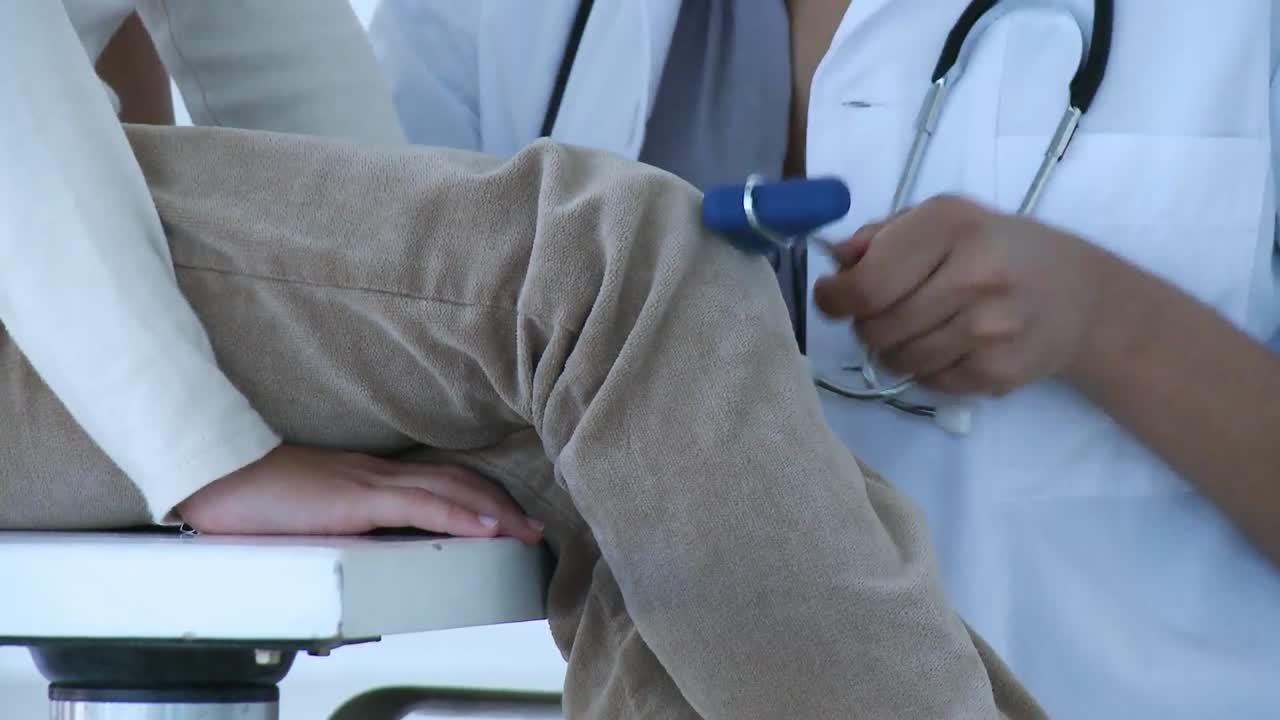Close up of doctor checking little girls reflexes