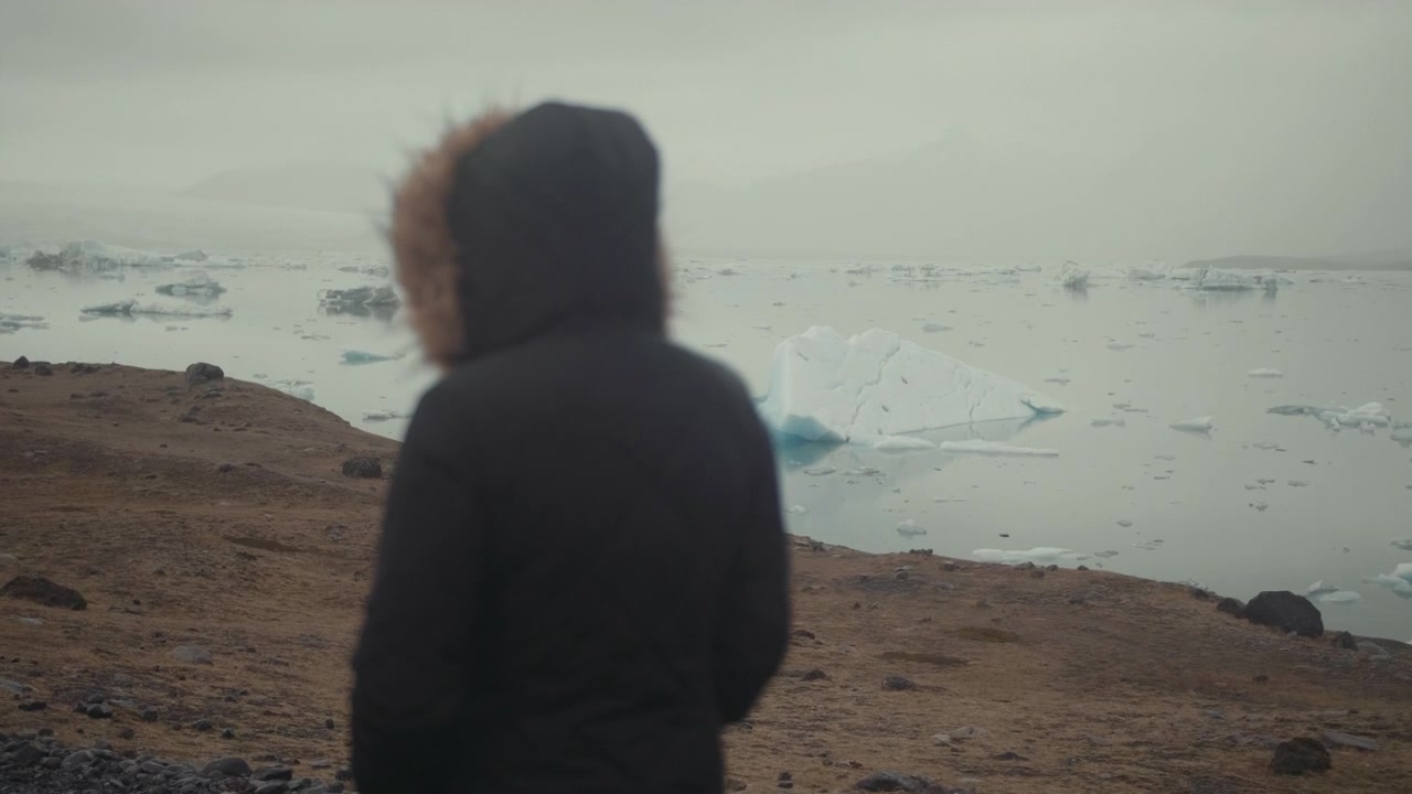 Blurred Person in Winter Coat Overlooking a Glacial Lagoon
