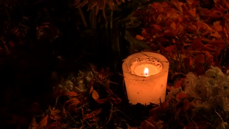 close up of candles with a grave in the mexican cemetery of mixquic during celebration of the day of the dead