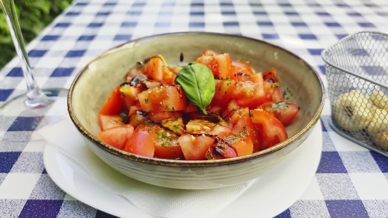 A panning shot of a fresh tomato salad at a small family bistro in Italy.
