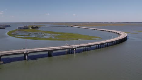 drone establishing orbit along highway through swamp wetlands to chincoteague island virginia, slow motion