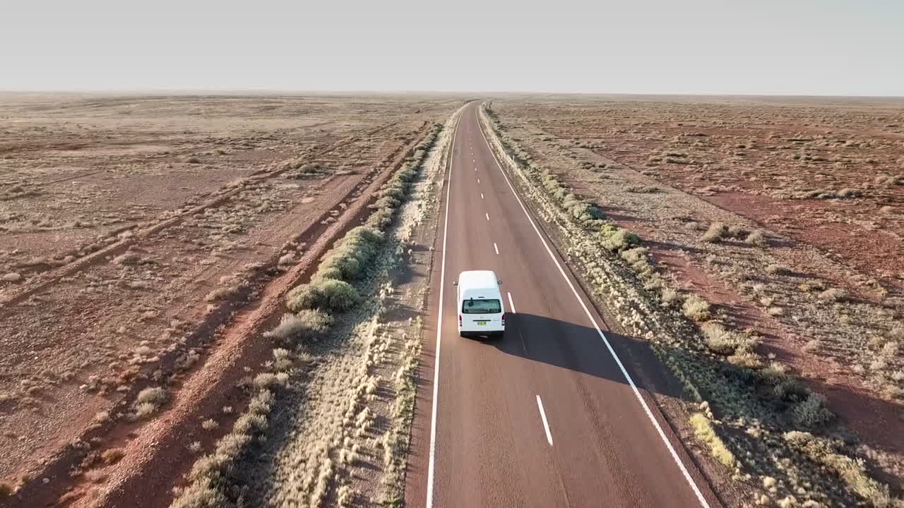 AERIAL FOLLOWING - A lone van travelling deep in the vast Australian Outback
