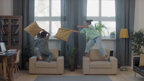 mixed-race siblings pillow-fighting in living room
