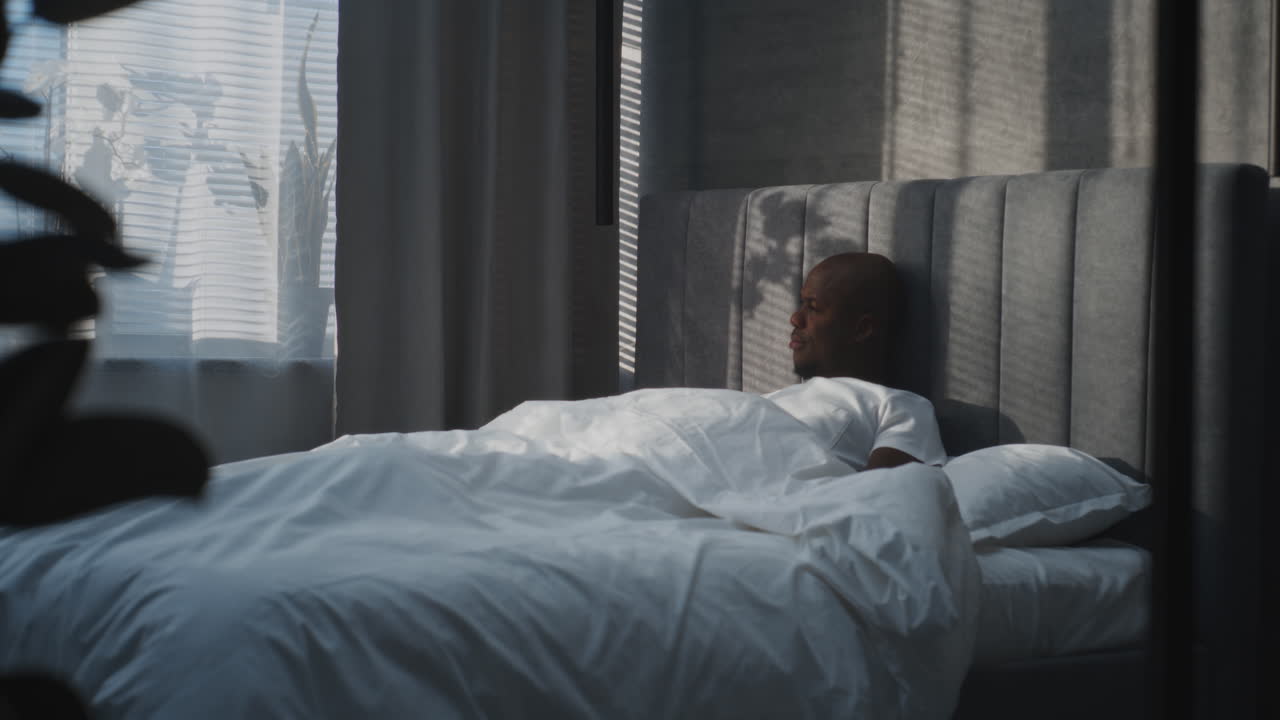 Man resting in bed in bedroom