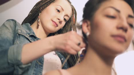 el peluquero haciendo dreads para una joven mujer sonriente en la peluquería. filmado en 4k