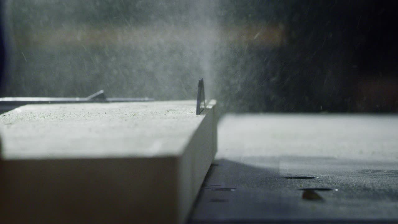 목공 공장의 작업실에서 목공 기계에서 일하는 전문 목공의 근접 사진.