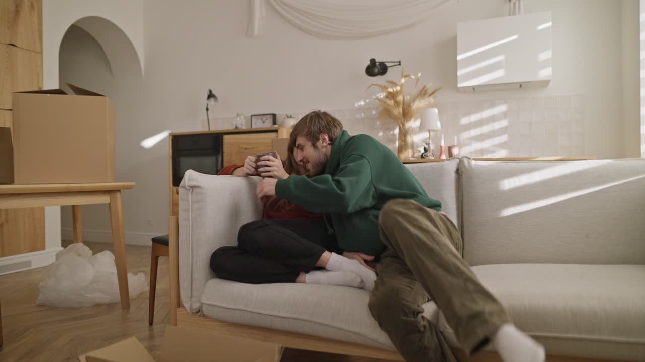 пара отдыхает на диване во время переезда