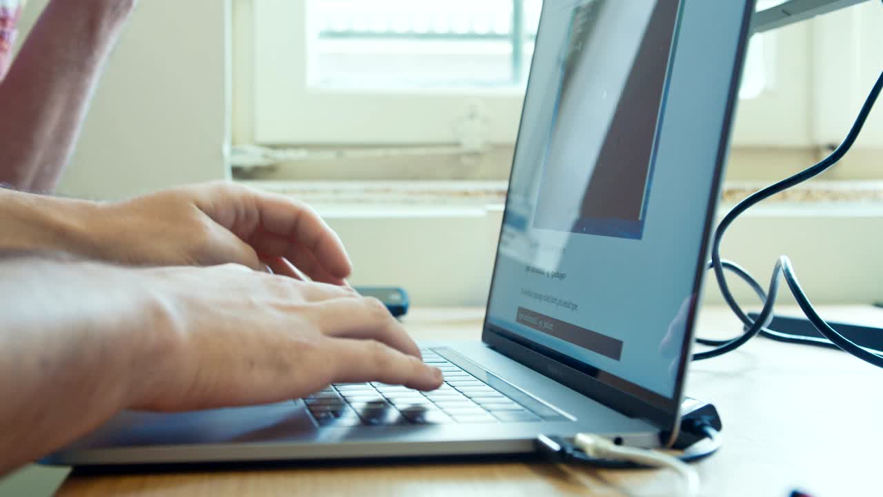manos del hombre escribiendo en un teclado de computadora portátil