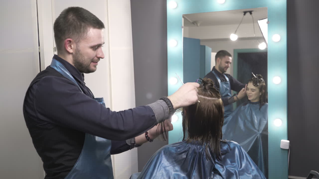 Parrucchiera che taglia i capelli alla sua cliente in un salone di parrucchiere.