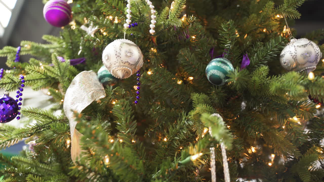 árbol de navidad tradicional decorado con adornos de bolas cuentas luces púrpura azul plata blanco