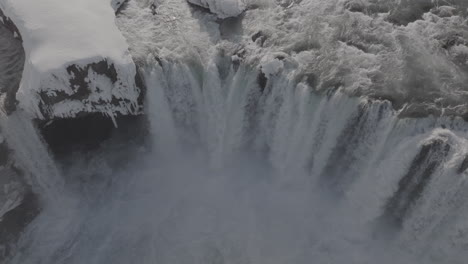 aerial view of cold glacial water falling into canyon on sunny winter day, iceland