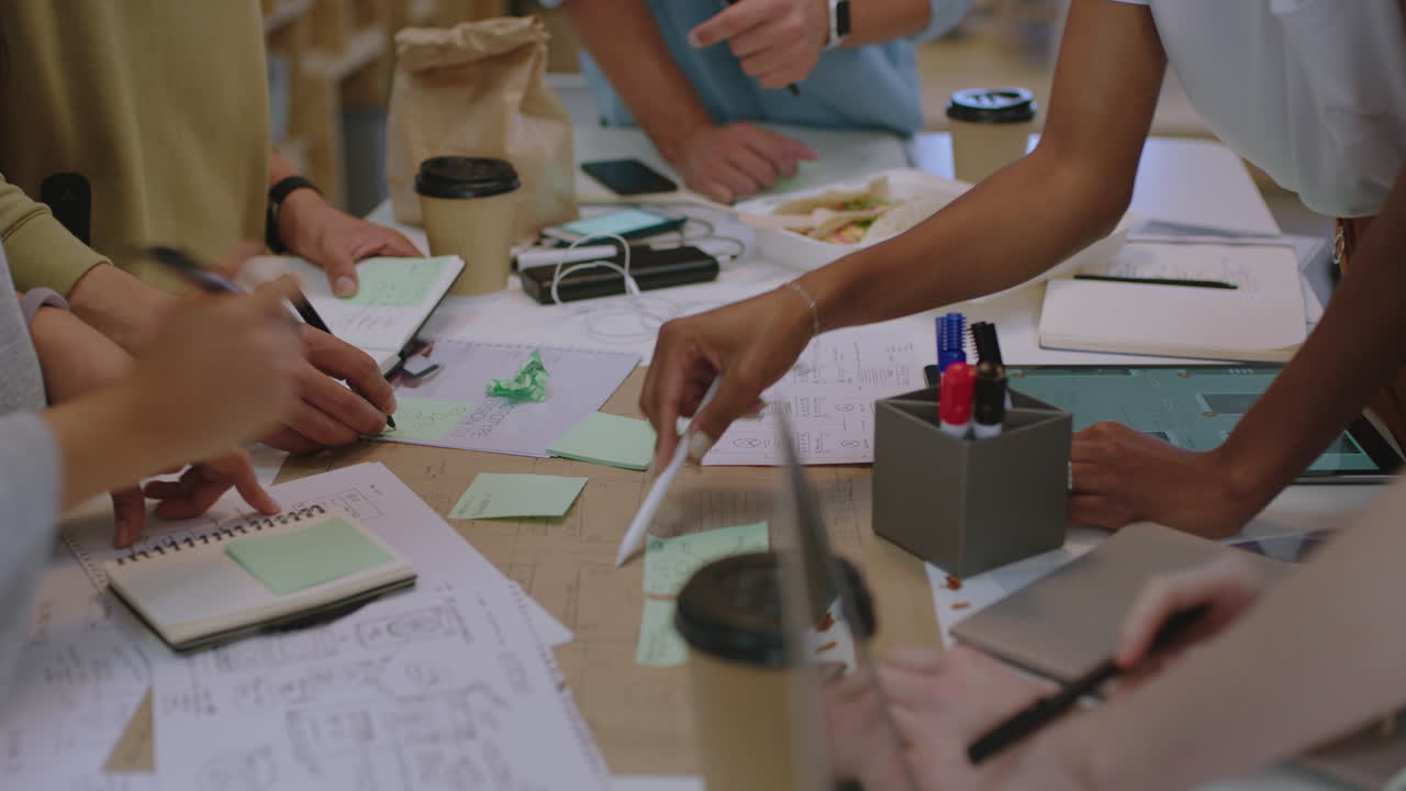 젊은 사업가 들 이 소프트웨어 개발자 팀 을 만나 휴대 전화 응용 프로그램 을 디자인 하는 다양 한 그룹 브레인 스토밍 커뮤니케이션 응용 프로그램 을 위한 창조적 인 아이디어 를 공유 하는 것