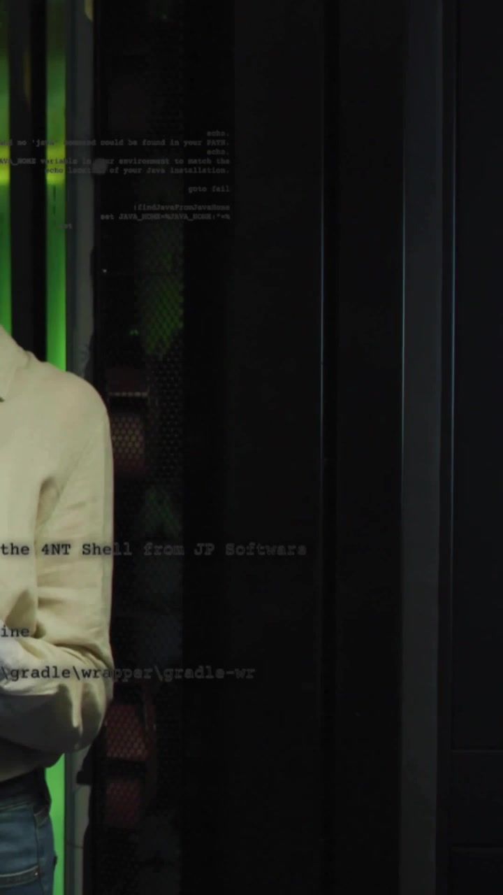 IT-tekniker står i datacenter, tapper på telefon, tjekker servere, konsoltekst svarer nær grønne LED'er.