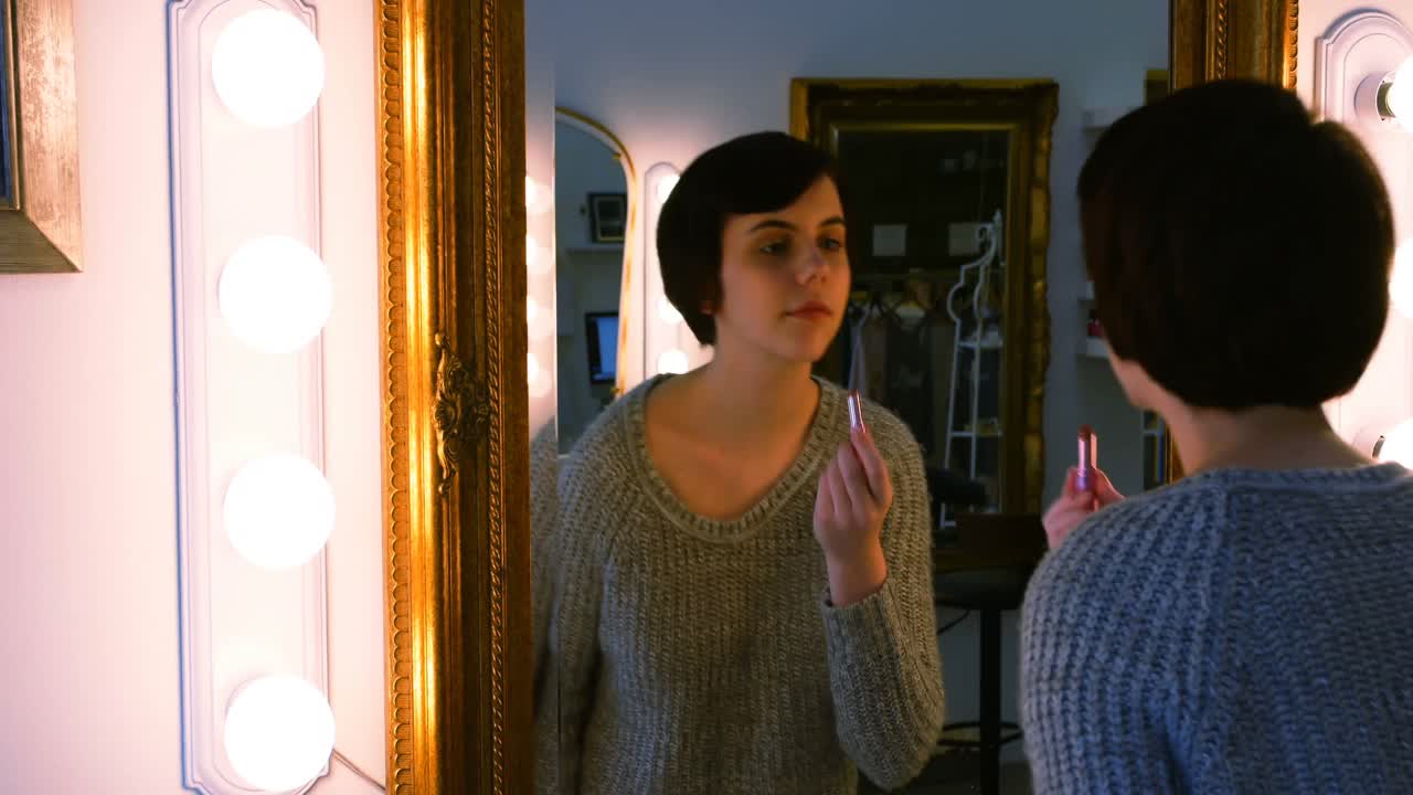 거울 을 보면서 립스틱 을 쓰는 여자