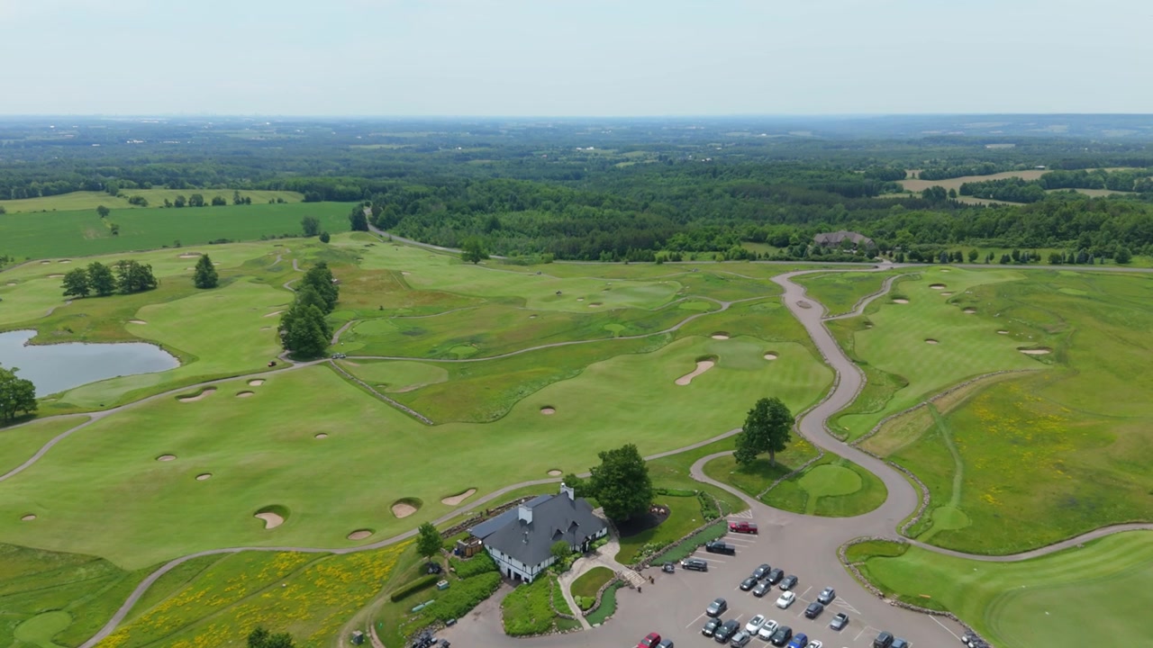 Stunning drone video captures the scenic Paintbrush Golf Course at Pulpit Club in Caledon, Ontario, with lush fairways, rolling greens, clear skies, panoramic countryside and vibrant summer lighting.