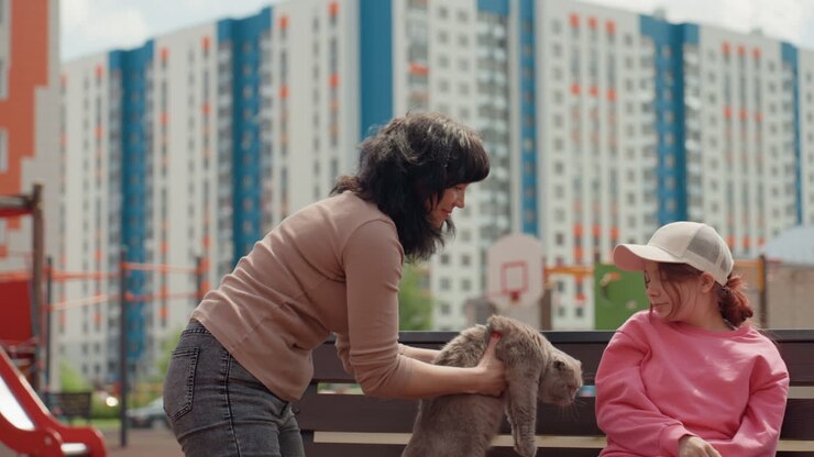 Bambino osserva una donna che presenta un felino, donna presenta il suo animale domestico a un bambino che guarda attentamente, una donna adulta mostra il suo felino a un bambino piccolo che osserva con interesse
