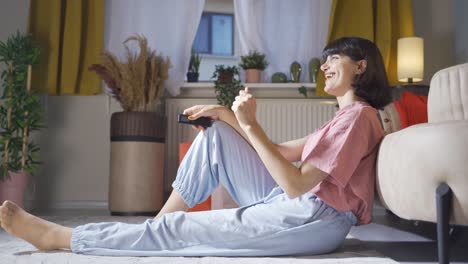 la mujer que mira la televisión se alegra.