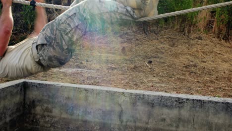 soldado militar subiendo la cuerda durante un curso de obstáculos