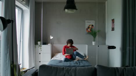 woman working on laptop in a modern bedroom