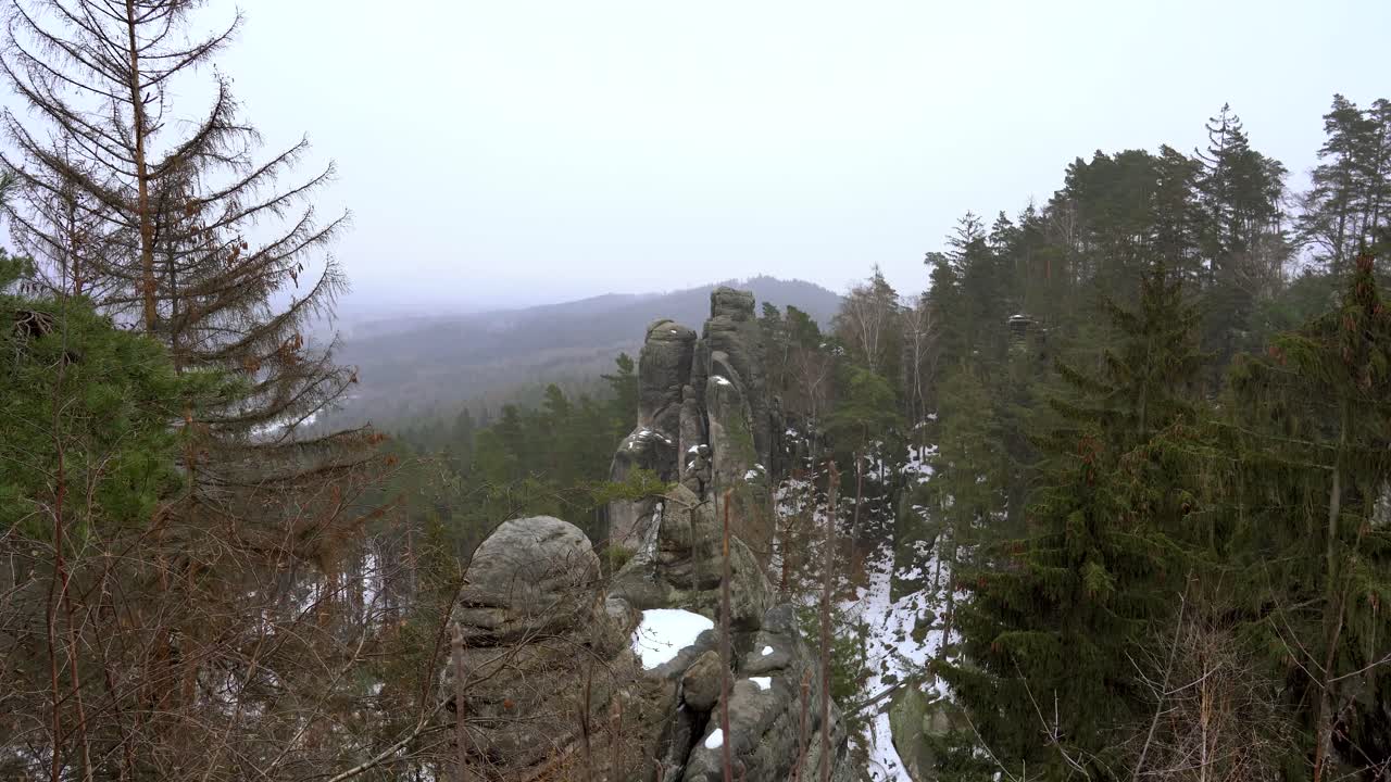 perspectiva sobre una formación rocosa de arenisca en rocas prachov, paraíso bohemio, en invierno con copos de nieve voladores, camión a la derecha