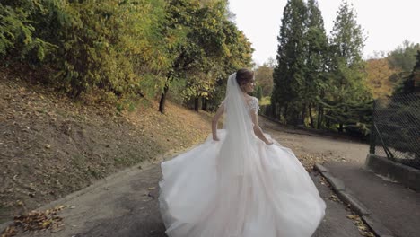 bride walking down a path in the woods