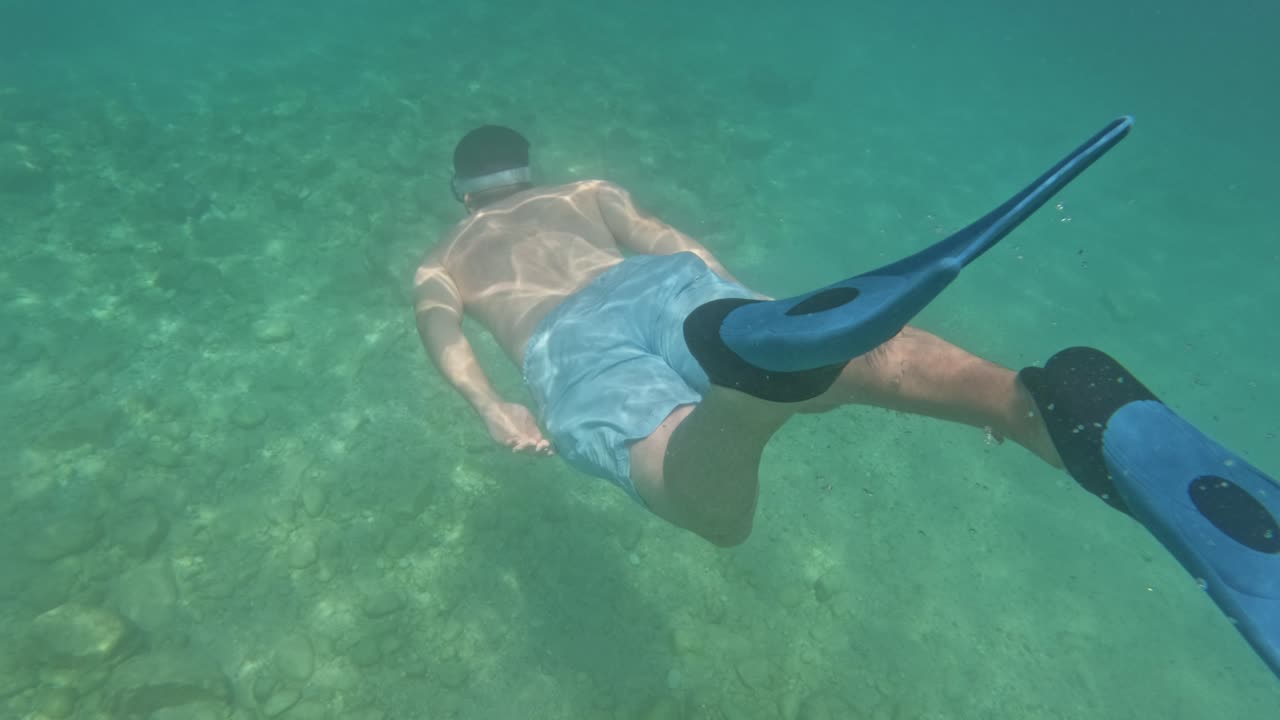 A Tourist Snorkeling Going Underwater